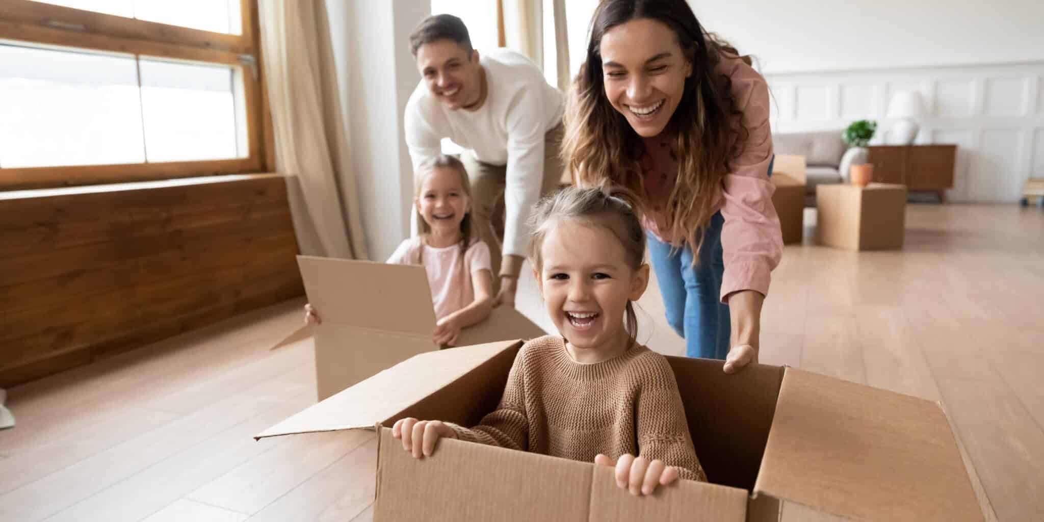 happy-parents-playing-with-little-kids-riding-in-box